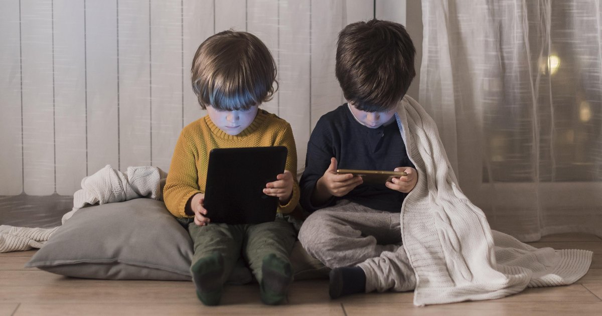 full-shot-kids-sitting-with-devices