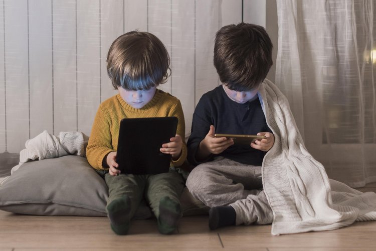 full-shot-kids-sitting-with-devices